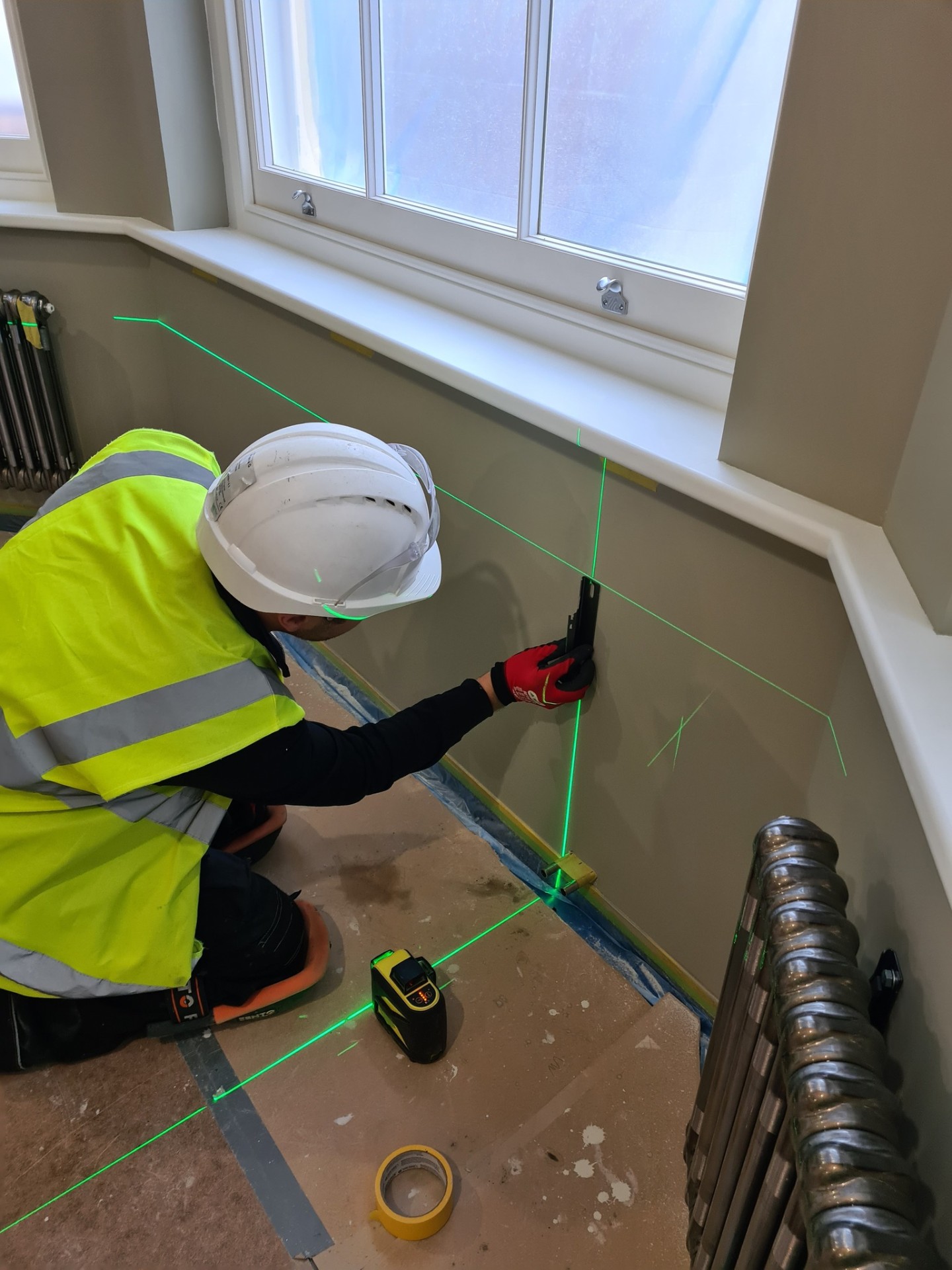 Using laser level to align radiator brackets for perfect installation