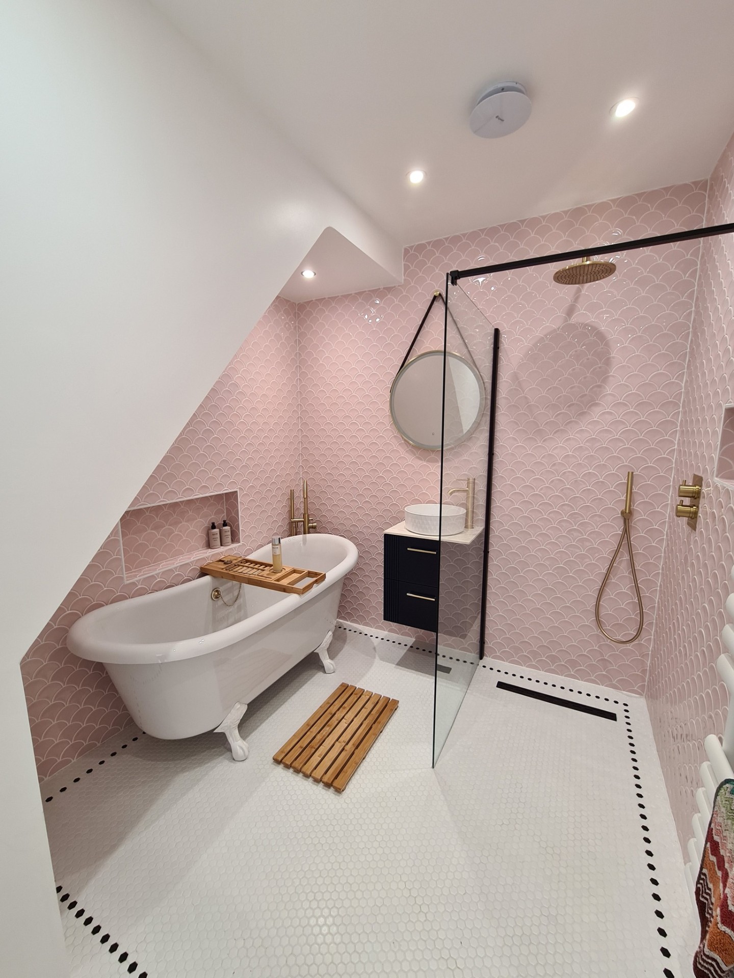 Luxury bathroom with pink scallop tiles, freestanding clawfoot bath and walk-in shower