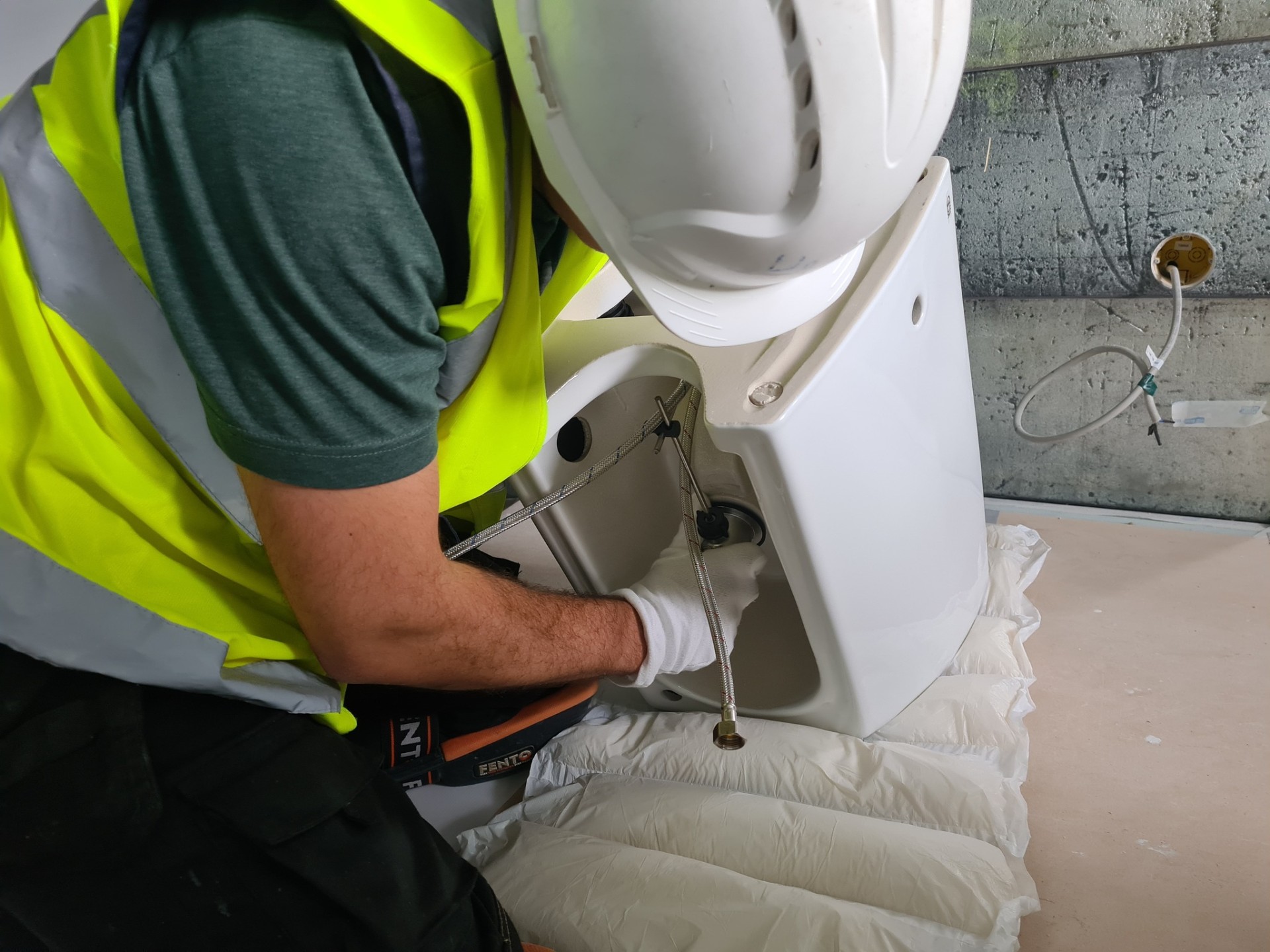 Pro Plumbing Team engineer installing close-coupled toilet in bathroom