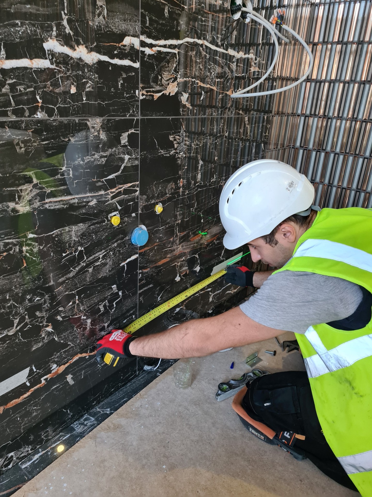 Engineer measuring marble tiles for precise bathroom installation